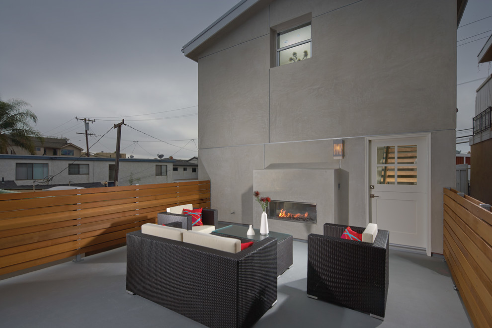 Inspiration pour une terrasse arrière design avec un foyer extérieur et aucune couverture.