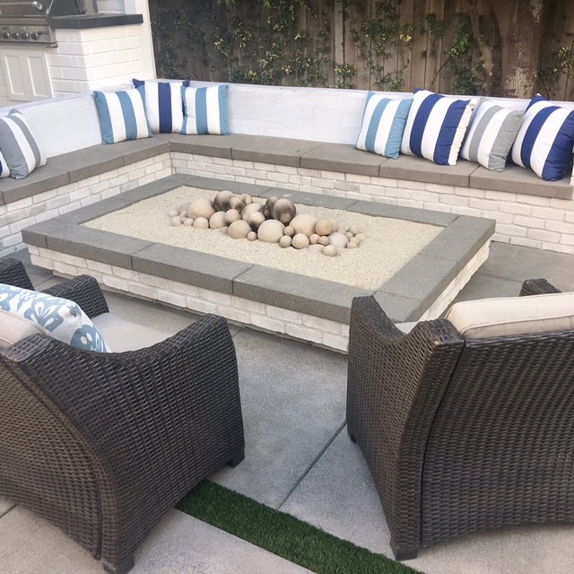 Inspiration for a mid-sized coastal backyard concrete paver patio remodel in Orange County with a fire pit and no cover