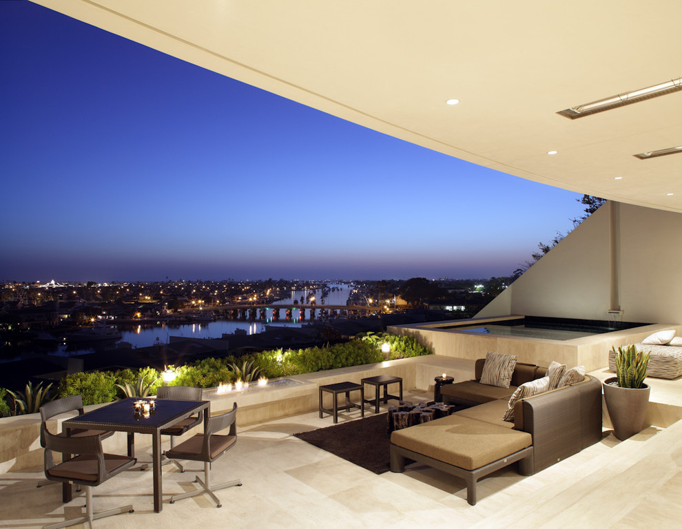 This is an example of a beach style patio in Los Angeles with a roof extension.