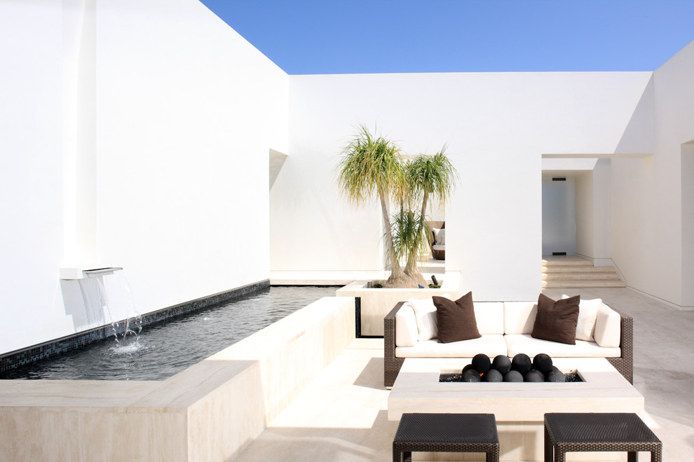 Inspiration for a contemporary courtyard patio remodel in Los Angeles with a fire pit