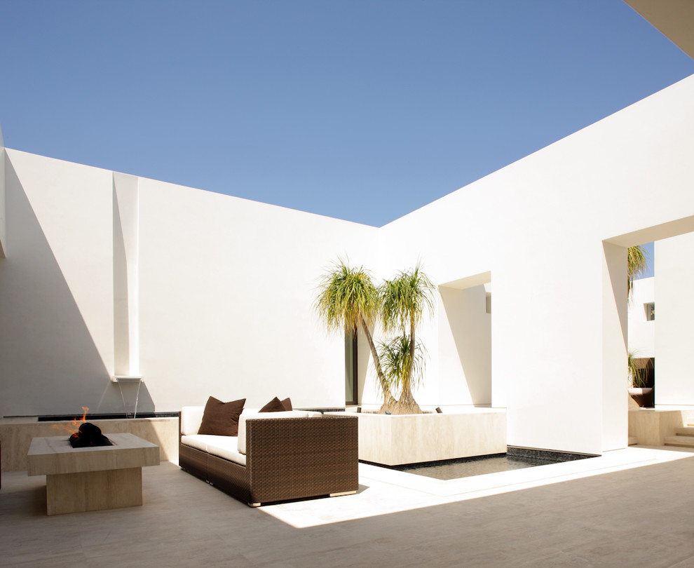 This is an example of a contemporary courtyard patio in Los Angeles with a fire feature.