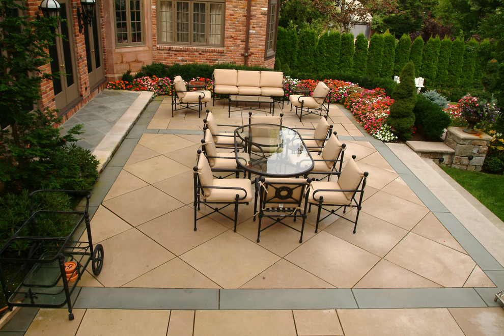 Example of a large classic backyard concrete paver patio design in Boston with no cover