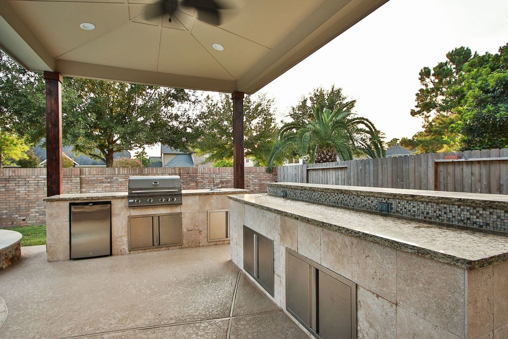 Modelo de patio actual grande en patio trasero con cocina exterior, losas de hormigón y cenador