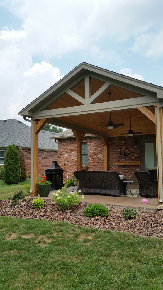 Patio - mid-sized traditional backyard concrete patio idea in Louisville with a fire pit and a roof extension
