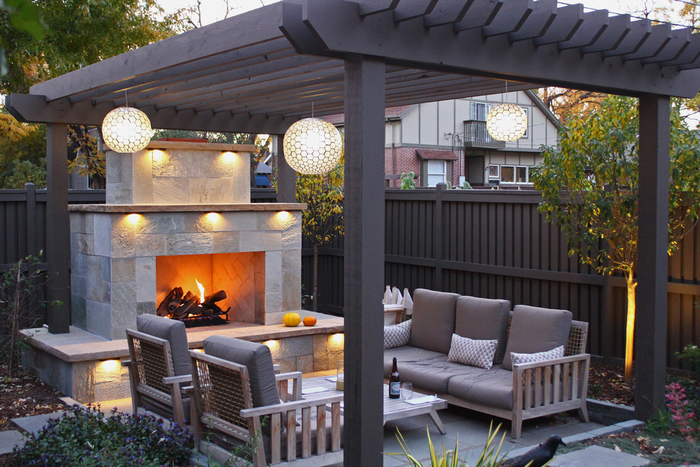 Imagen de patio clásico en patio trasero con adoquines de piedra natural y chimenea