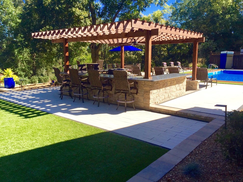 Inspiration for a large contemporary back patio in Indianapolis with an outdoor kitchen, concrete paving and a pergola.