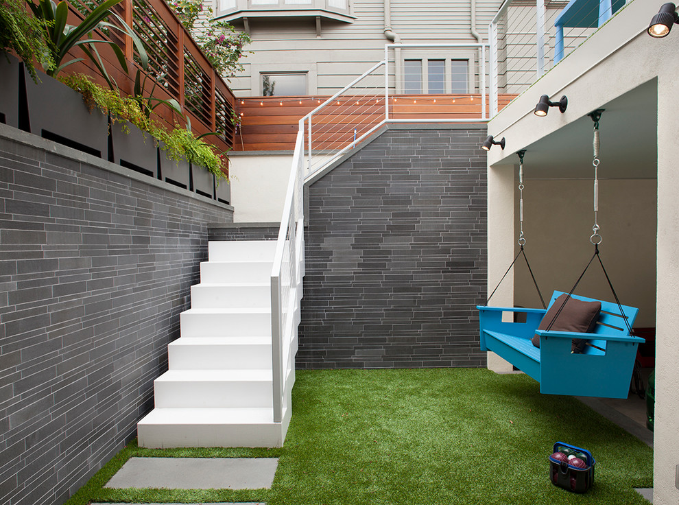Esempio di un grande patio o portico minimal in cortile con pavimentazioni in cemento e scale