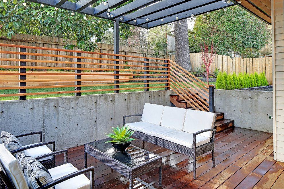 Medium sized scandinavian back patio in Seattle with a pergola.