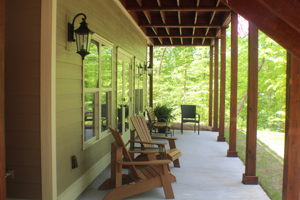 Idée de décoration pour une terrasse arrière craftsman avec une dalle de béton et une extension de toiture.