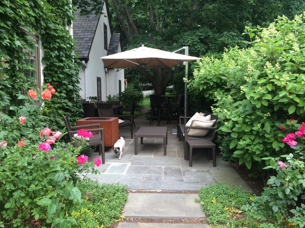 Small traditional back patio in New York with natural stone paving, a fire feature and no cover.