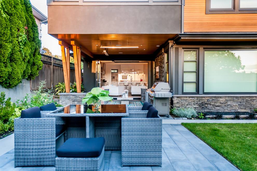 Medium sized contemporary back patio in Vancouver with an outdoor kitchen, concrete paving and a roof extension.