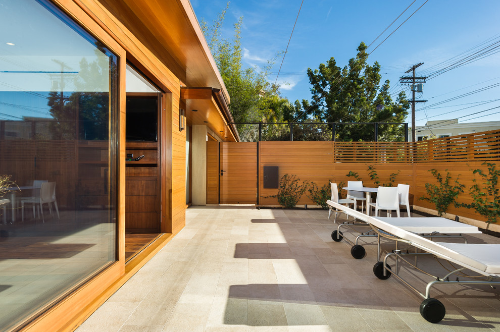 Photo of a medium sized modern patio in Los Angeles with tiled flooring and an awning.
