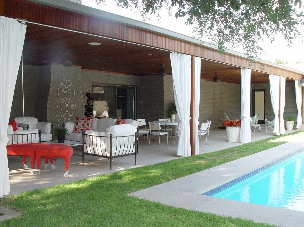 Example of a trendy patio design in Dallas with a roof extension