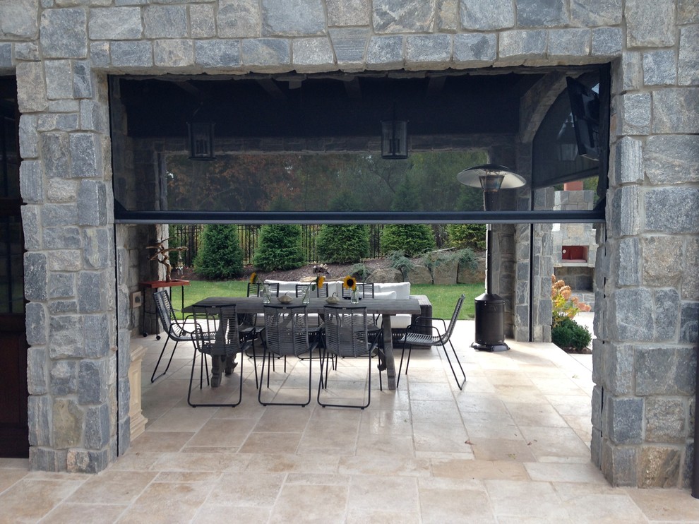 Cette image montre une terrasse arrière traditionnelle de taille moyenne avec une cuisine d'été, des pavés en pierre naturelle et une extension de toiture.