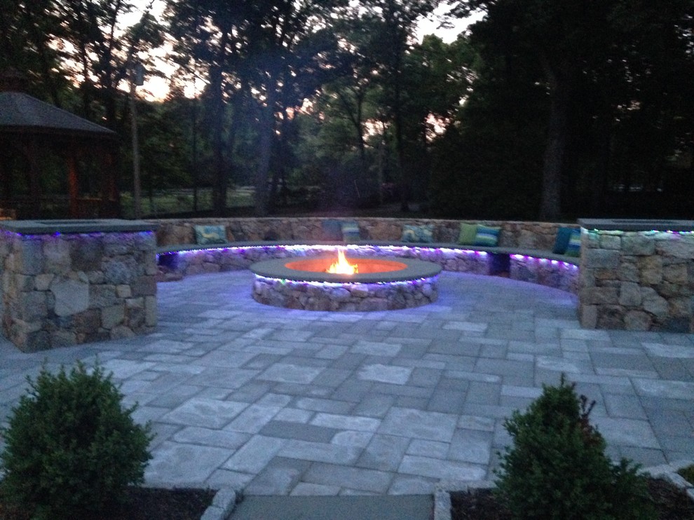 Example of a minimalist courtyard concrete paver patio design in Providence with a fire pit