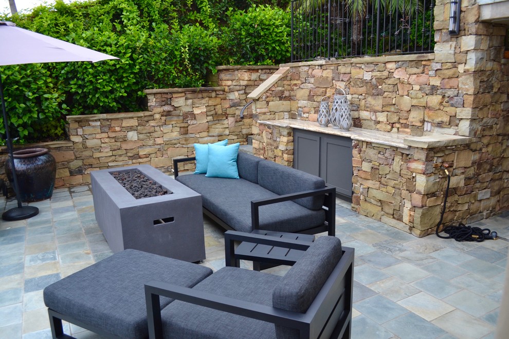Imagen de patio contemporáneo de tamaño medio sin cubierta en patio con brasero y adoquines de piedra natural