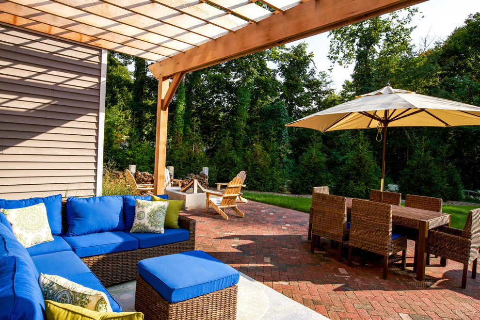 Inspiration for a medium sized contemporary back patio in Boston with brick paving and a pergola.