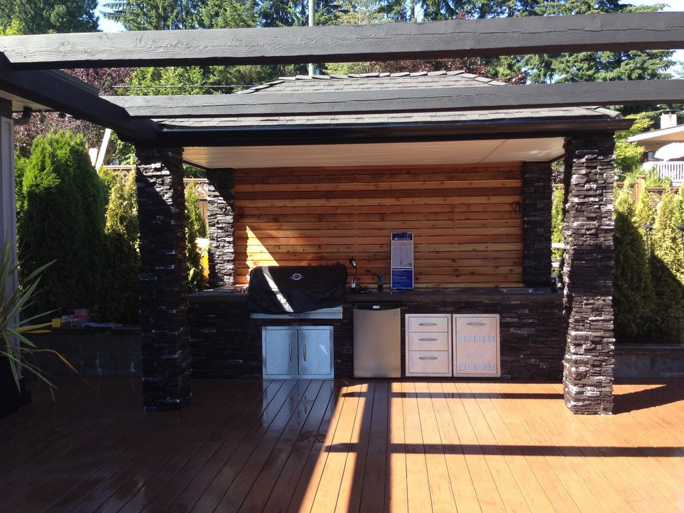 Cette image montre une terrasse en bois arrière traditionnelle de taille moyenne avec une cuisine d'été et une pergola.