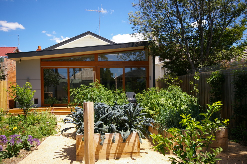 На фото: двор среднего размера на заднем дворе в современном стиле с растениями в контейнерах, настилом и навесом с