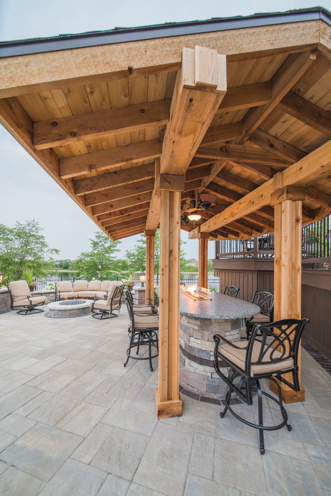 Inspiration for a large contemporary backyard stone patio remodel in Chicago with a fire pit and a pergola