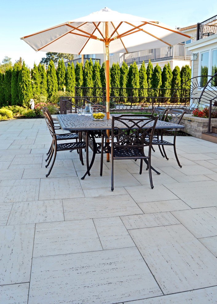 Esempio di un patio o portico minimalista dietro casa con pavimentazioni in cemento