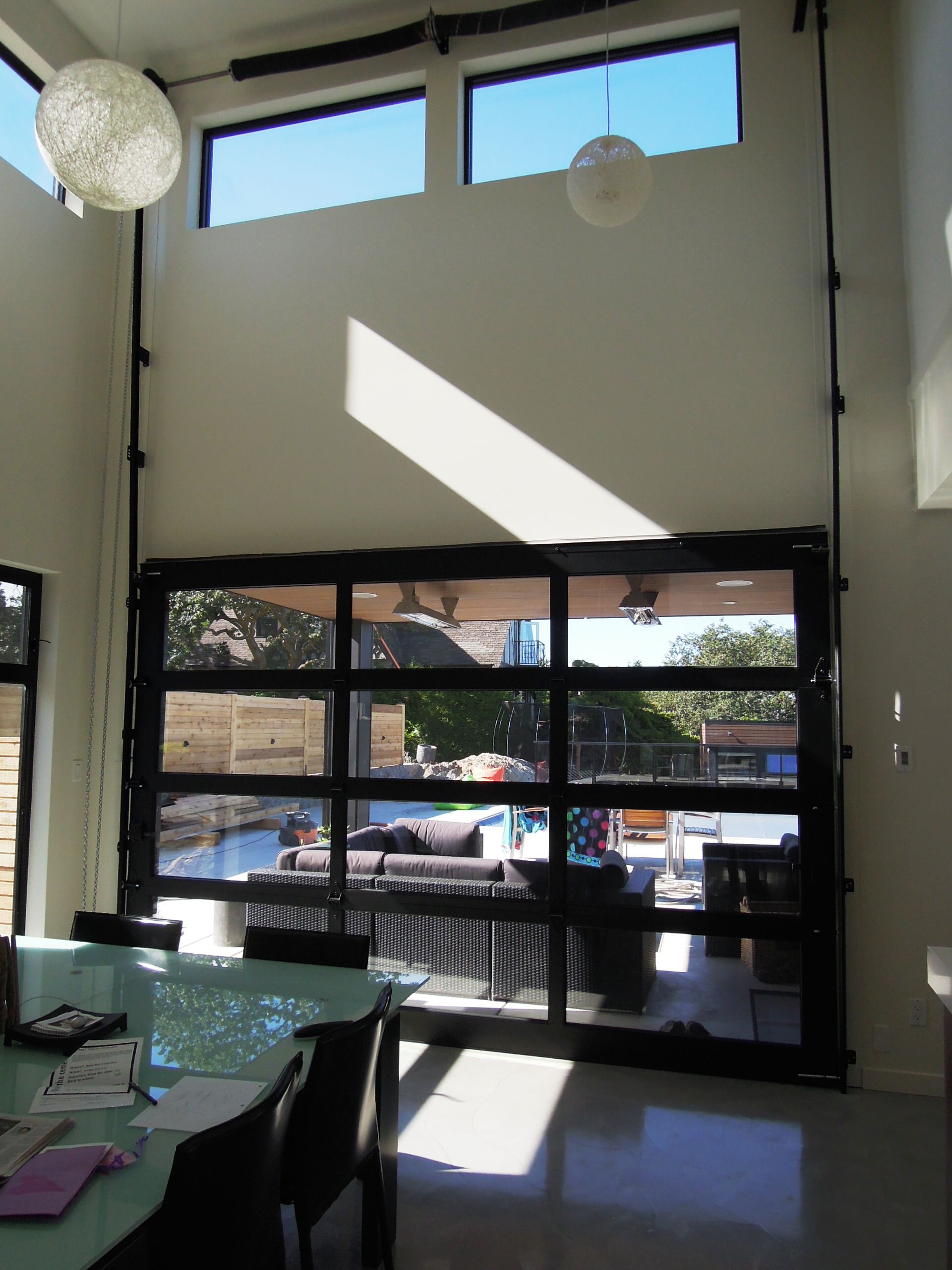 indoor outdoor living area in basement with garage door on Glass Garage Doors Patio Ideas Photos Houzz