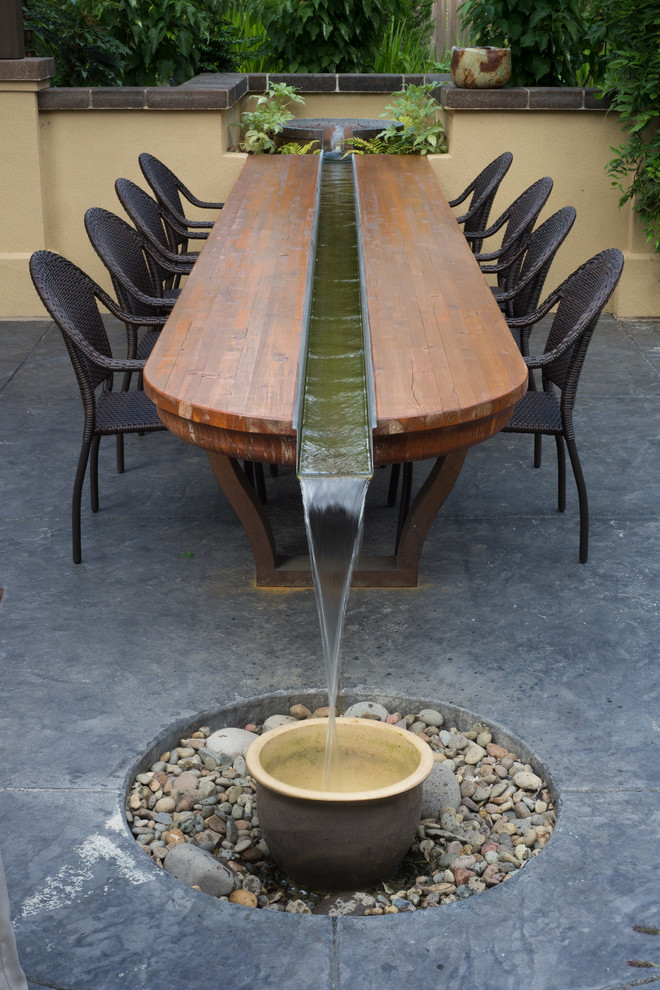 他の地域にある中くらいなトラディショナルスタイルのおしゃれな裏庭のテラス (噴水、スタンプコンクリート舗装、パーゴラ) の写真