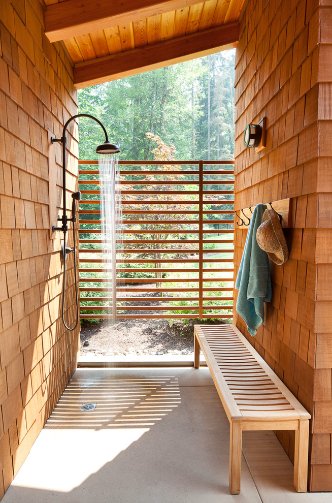 Idées déco pour une terrasse avec une douche extérieure arrière montagne avec une dalle de béton et une extension de toiture.