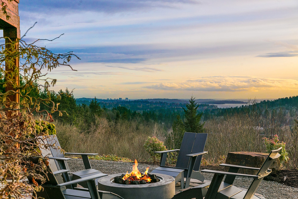 Example of a mountain style backyard gravel patio design in Seattle with a fire pit