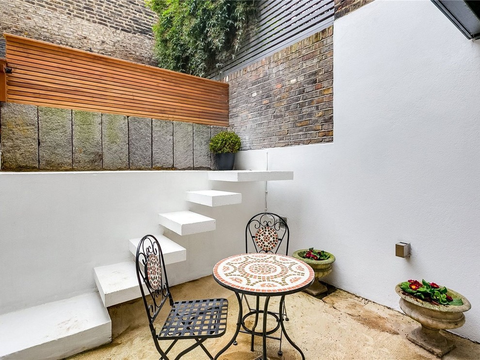 Kleiner, Unbedeckter Mediterraner Patio hinter dem Haus mit Betonplatten in London