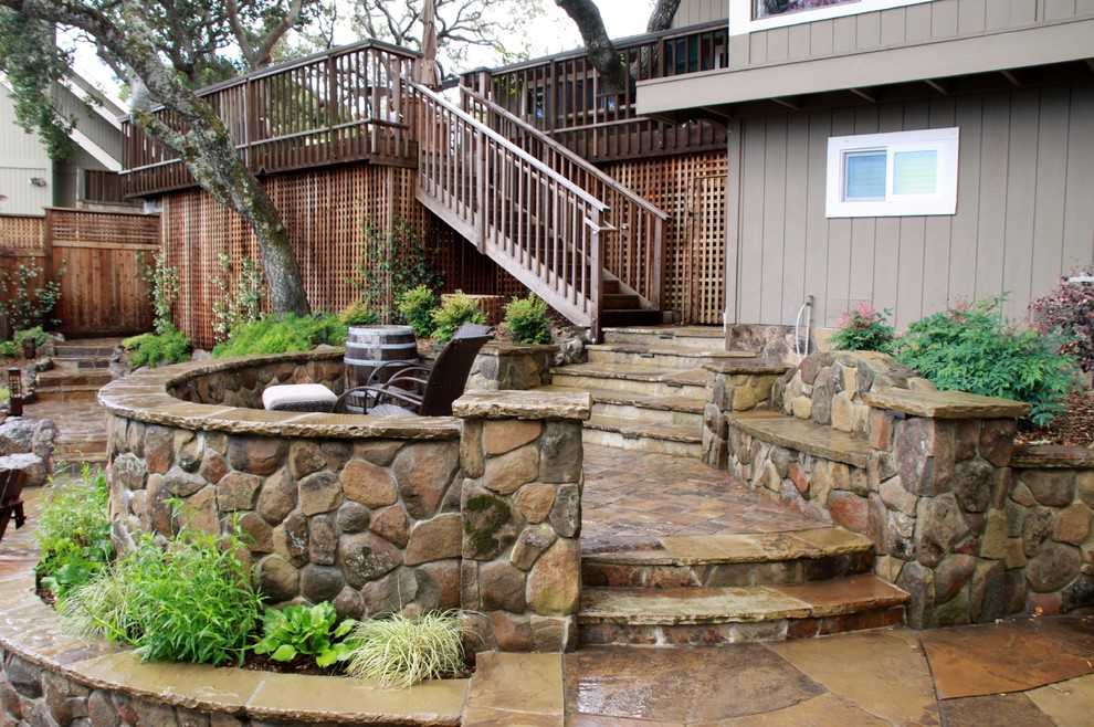 Photo of a large rustic back patio in San Francisco with concrete paving and no cover.
