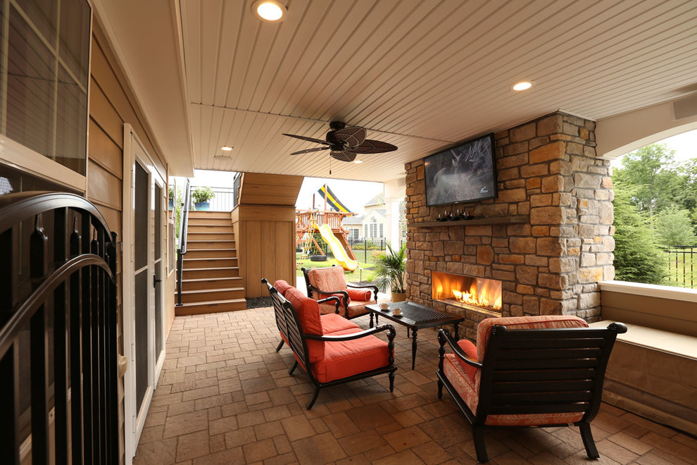 Example of a mid-sized trendy backyard concrete paver patio design in Philadelphia with a fire pit and a roof extension