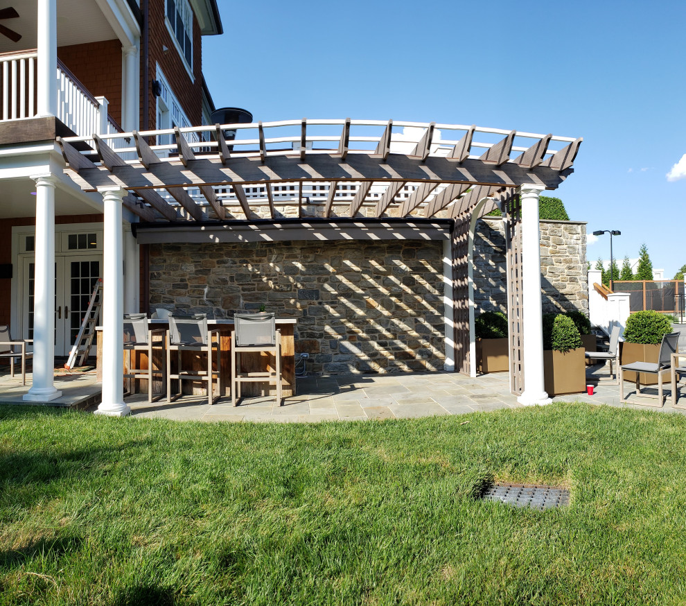 Diseño de patio de estilo americano de tamaño medio en patio trasero con cocina exterior, adoquines de piedra natural y toldo