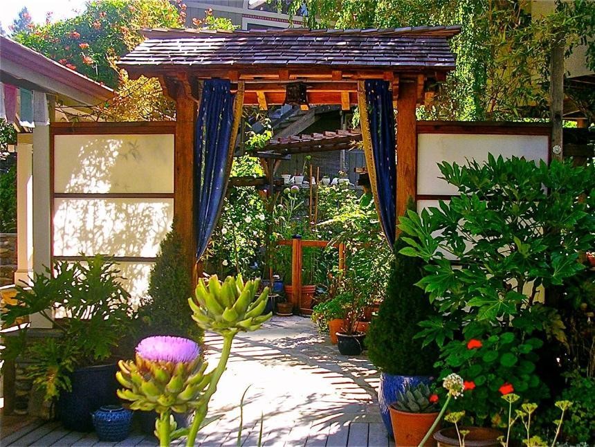 Foto de patio asiático de tamaño medio en patio lateral con jardín de macetas, adoquines de piedra natural y pérgola