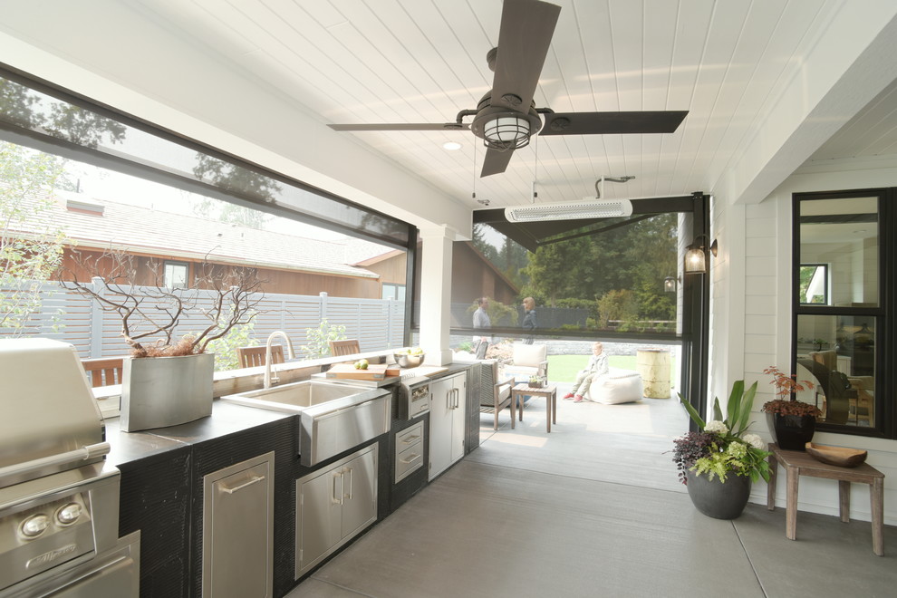This is an example of a rural back patio in Seattle with an outdoor kitchen and an awning.