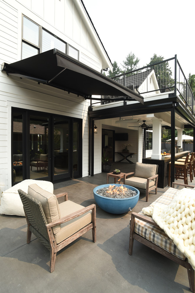Inspiration for a farmhouse back patio in Seattle with an outdoor kitchen and an awning.