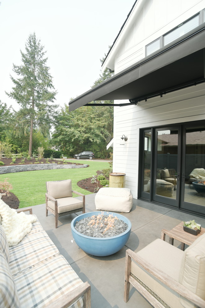 Photo of a farmhouse back patio in Seattle with an outdoor kitchen and an awning.