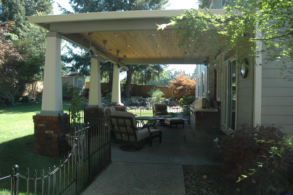 Immagine di un patio o portico tradizionale di medie dimensioni e davanti casa con lastre di cemento e un tetto a sbalzo
