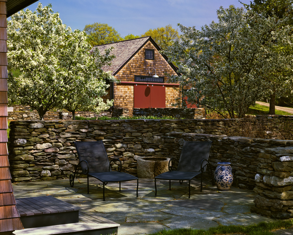 Patio - large farmhouse backyard stone patio idea in Boston with no cover