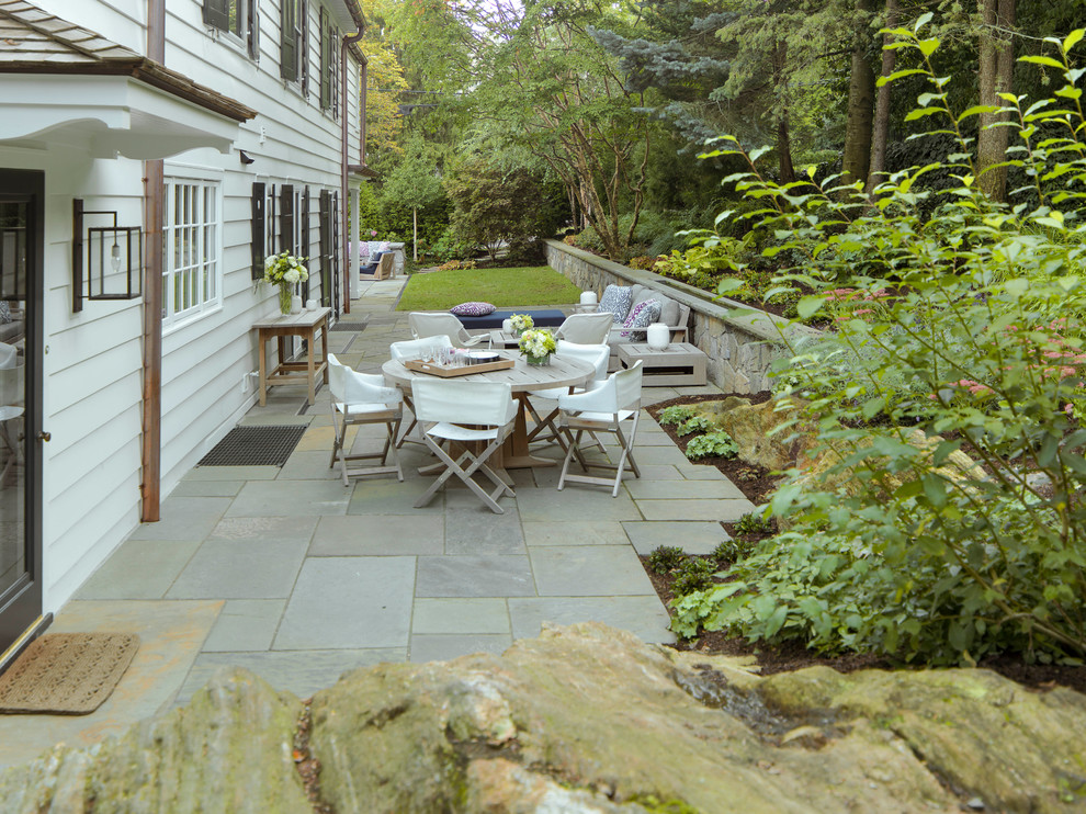 Patio - mid-sized transitional backyard stone patio idea in New York with no cover