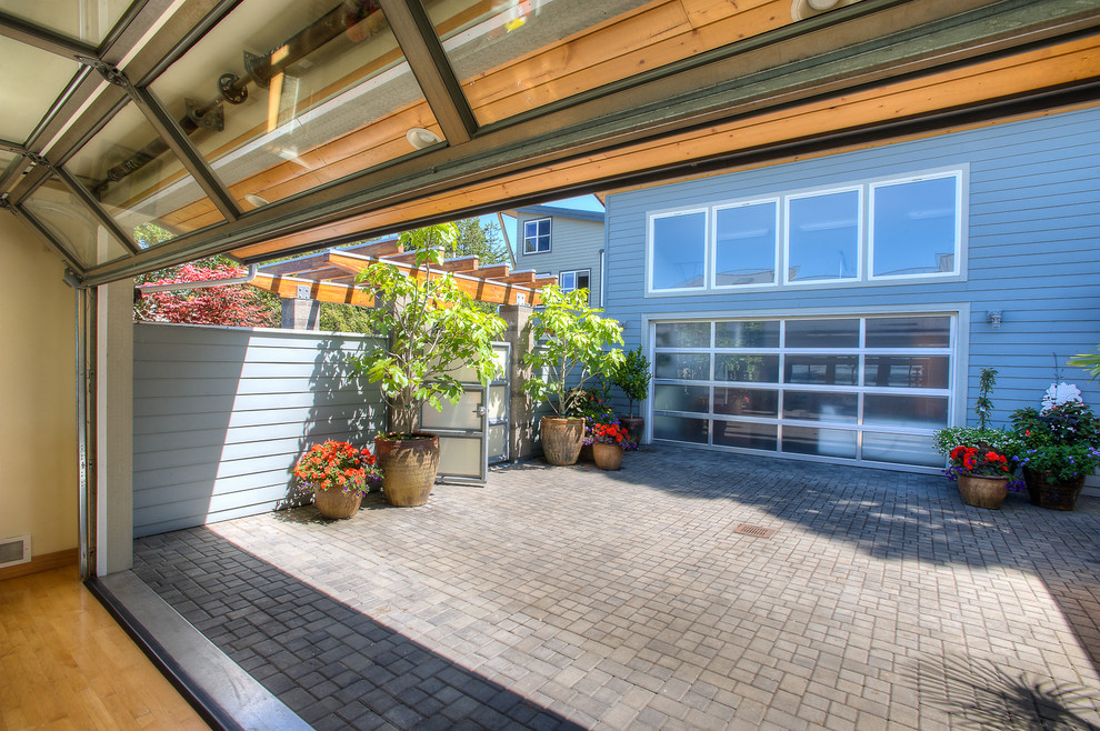 Foto de patio minimalista de tamaño medio en patio con jardín de macetas, adoquines de ladrillo y pérgola