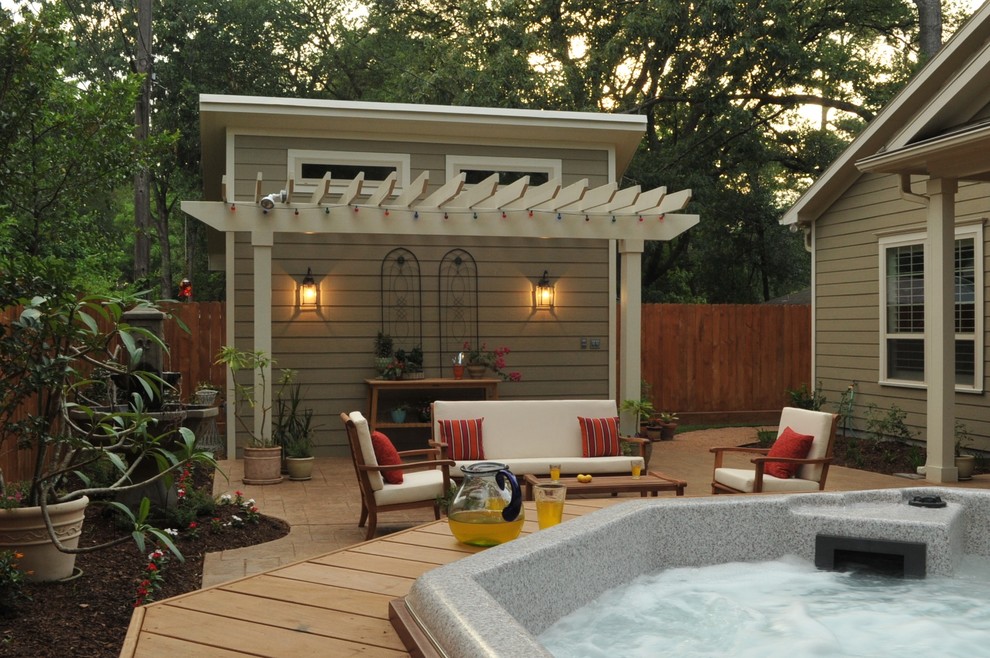 Diseño de patio clásico en patio trasero con fuente, suelo de hormigón estampado y pérgola