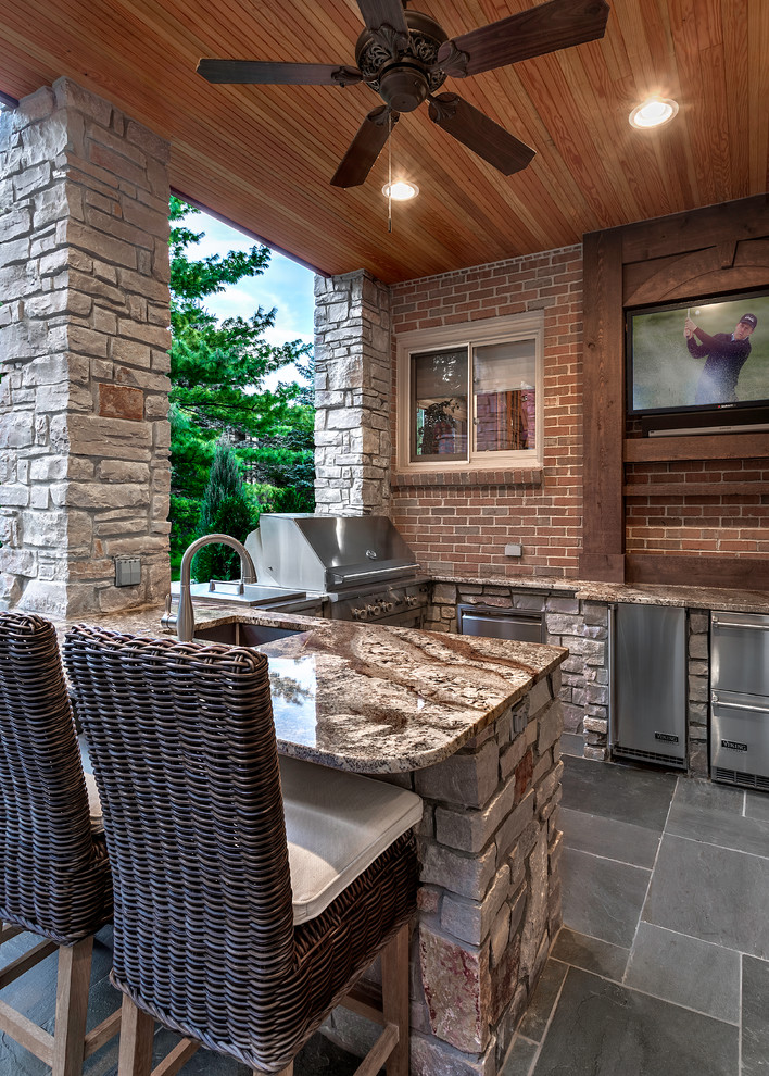 Photo of a medium sized contemporary back patio in Detroit with an outdoor kitchen, natural stone paving and a pergola.