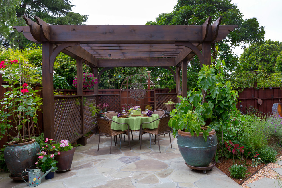 Example of a mid-sized asian backyard stone patio fountain design in San Francisco with a pergola