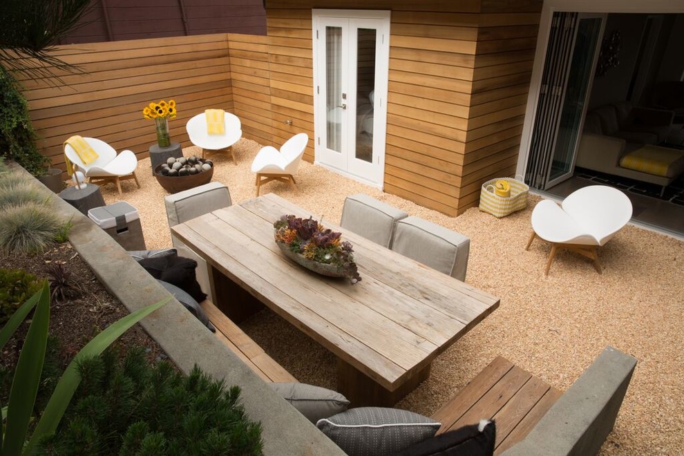Imagen de patio retro de tamaño medio sin cubierta en patio trasero con cocina exterior y gravilla