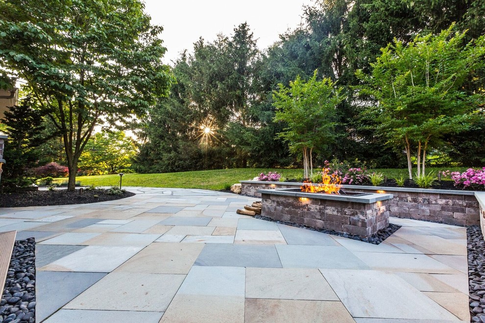 Modelo de patio clásico renovado grande en patio trasero con brasero, adoquines de piedra natural y cenador