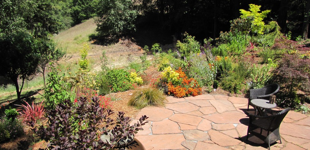 Large bohemian back patio in San Francisco with natural stone paving.
