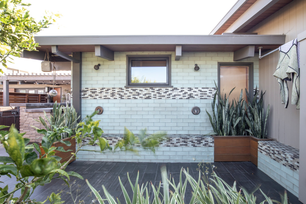 Example of a 1950s tile outdoor patio shower design in Orange County with a roof extension