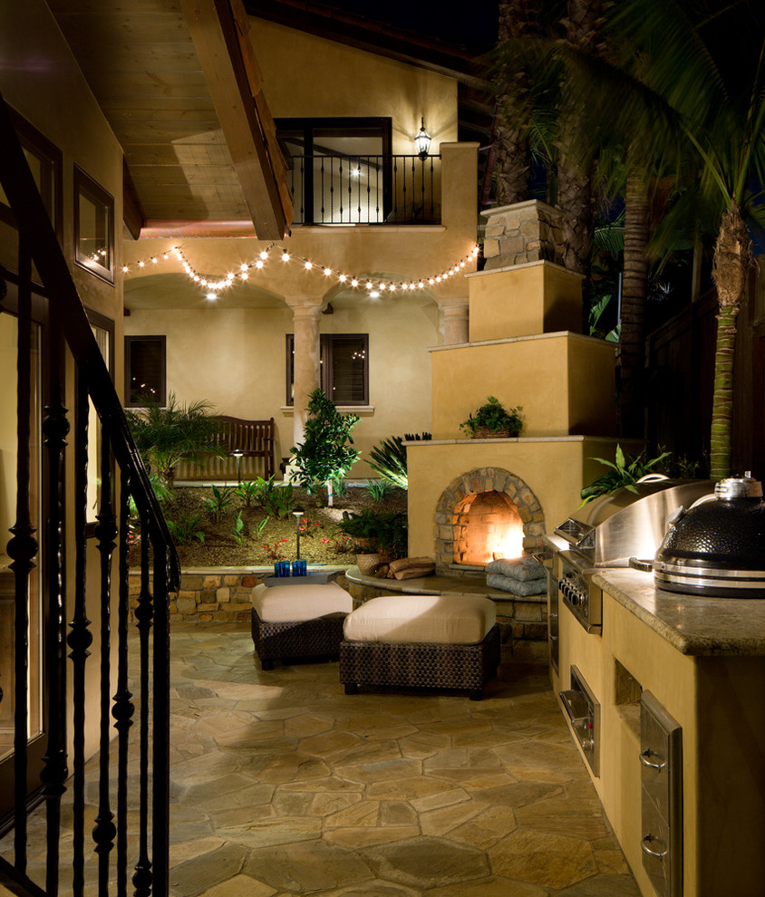 Medium sized mediterranean back patio in San Diego with natural stone paving.