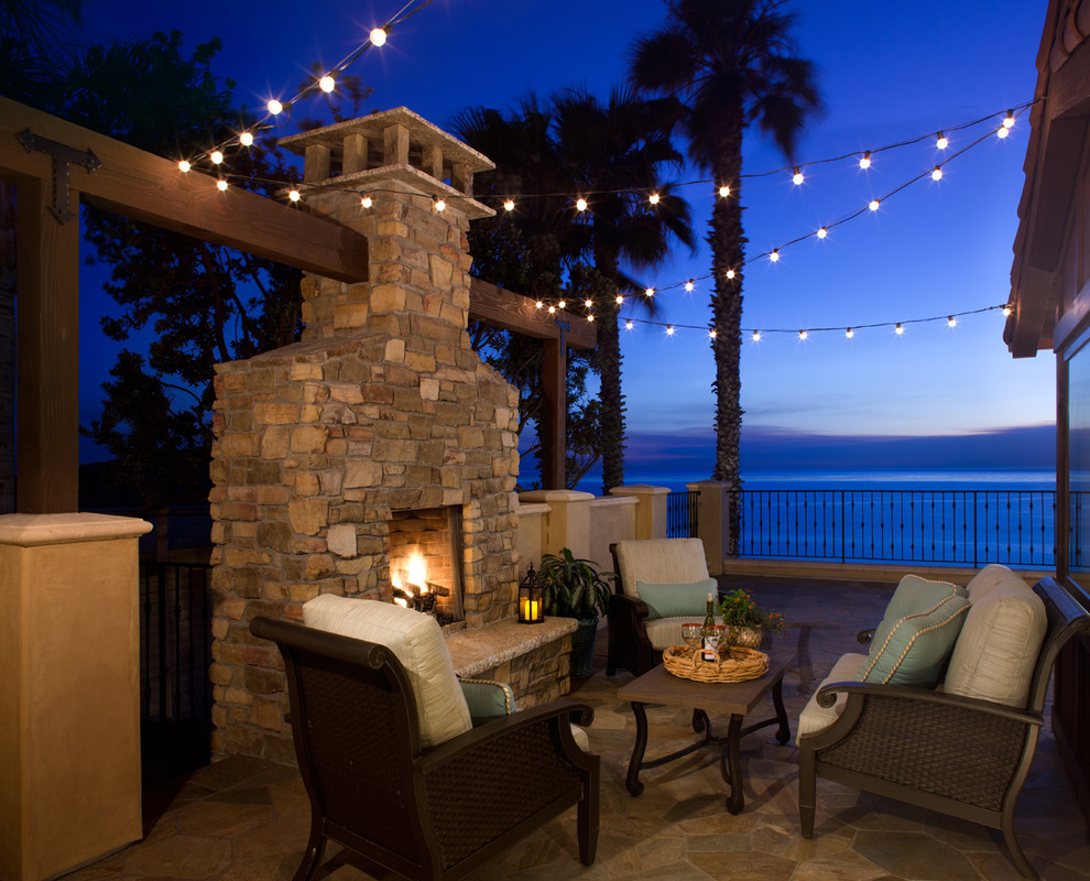 Inspiration for a medium sized mediterranean patio in San Diego with natural stone paving, no cover and a fireplace.